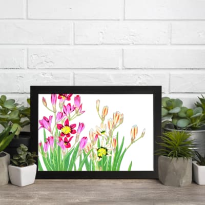 Vintage floral wall art with pink, yellow, and cream flowers and green leaves, framed in black. displayed on the wall