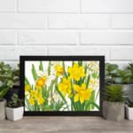 Infidu Vintage Floral Wall Art with bright orange flowers, dark green leaves, and a black frame on a white background. displayed on the wall