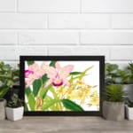Vintage floral wall art with pink and yellow flowers, green leaves, and a black frame on a white background. displayed on the wall