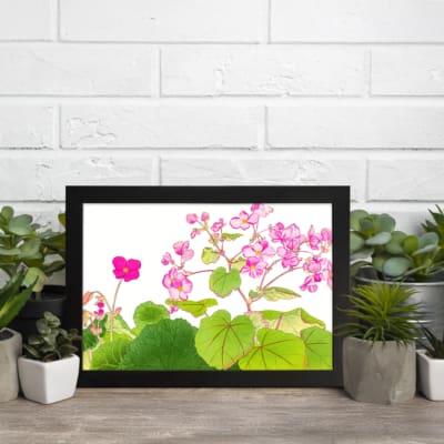 Infidu Vintage Floral Wall Art with pink flowers and green leaves on a white background, framed in black for a classic and elegant look. displayed on the wall.