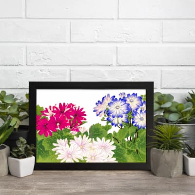 Vintage floral wall art with pink, white, and blue flowers surrounded by green leaves on a white background, framed in black for an elegant look. displayed on the wall