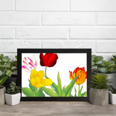 Vintage floral wall art with colorful tulips in red, yellow, orange, and white with pink streaks, surrounded by green leaves and framed in black. displayed on the wall