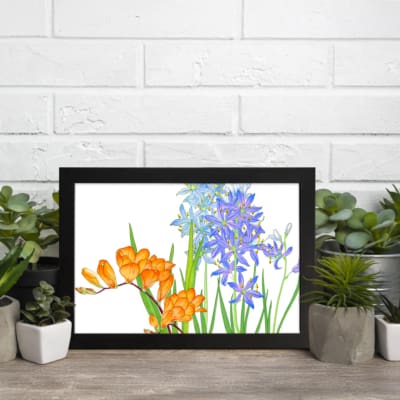 Vintage floral wall art with orange and blue flowers, green leaves, and a white background, framed in black for a classic and elegant look. displayed on the wall