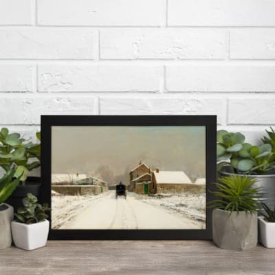 Vintage winter wall art with a snowy village, stone houses, and a black horse-drawn carriage on a snow-covered road, framed in black. displayed on the wall