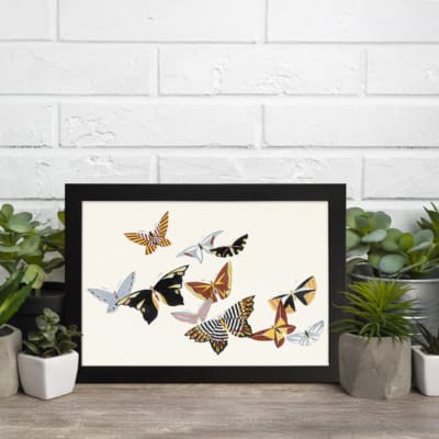 Infidu Vintage Wall Art with multicolored butterflies in black, white, gold, and brown on a soft off-white background. displayed on the wall in a black frame