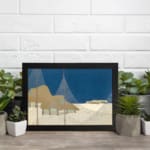 Vintage abstract wall art with a minimalist landscape design, featuring deep blue, beige, and brown tones in geometric shapes with a black frame. displayed on the wall