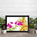 Infidu Vintage Floral Wall Art with bright pink and yellow-orange flowers, green leaves, and a black frame on a white background. displayed on the wall