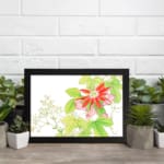 Infidu Vintage Floral Wall Art with a bright red flower, pink buds, green leaves, and small white flowers on a white background with a black frame. displayed on the wall