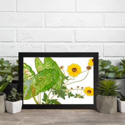 Vintage floral wall art with bright yellow flowers, green leaves, and a black frame on a white background. displayed on the wall