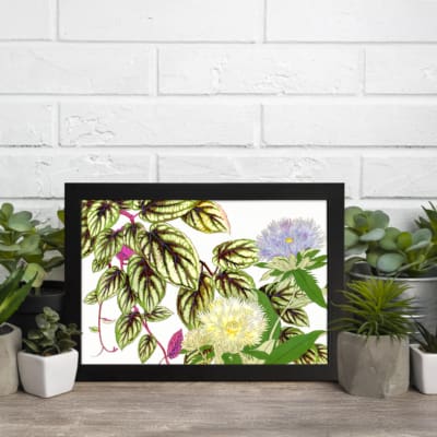 Vintage floral wall art with soft yellow and light purple flowers, green leaves with dark veins, and a white background. displayed on the wall in a black frame