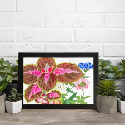 Vintage wall art featuring brown leaves with pink patterns and delicate blue, pink, and white flowers on a white background, framed in black. displayed on the wall