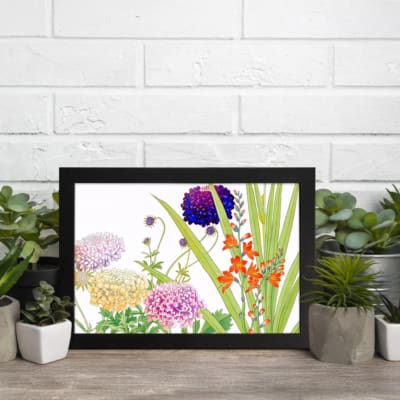 Vintage floral wall art featuring multicolor flowers in purple, pink, yellow, and orange with green leaves, set against a white background in a black frame. displayed on the wall.