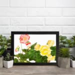 Infidu vintage wall art with detailed floral vintage art design, featuring pink, red, and yellow flowers with green leaves on a white background. displayed on the wall art in a black frame