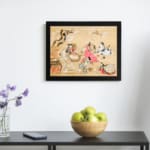 Traditional Asian garden scene with people in colorful robes sitting among trees and flowers on a beige background. displayed on the wall in a black frame