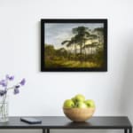 Vintage wall art of a serene forest with sunlight streaming through trees and distant hills in the background. displayed on the wall in a black frame