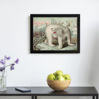 Vintage wall art featuring a polar bear in an icy Arctic landscape with icebergs, explorers, and a soft blue and pink sky. displayed on the wall in a black frame