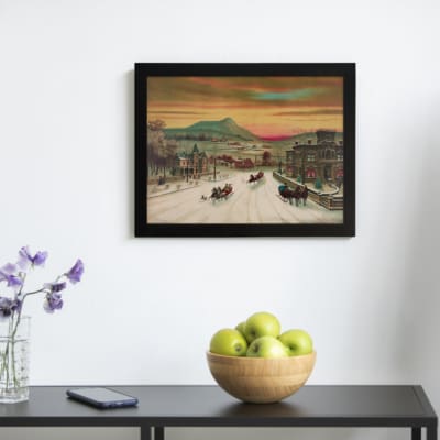 Infidu vintage wall art of a winter scene with horse-drawn sleighs passing through a snowy town, featuring warm sky tones and a peaceful landscape. displayed on the wall art in a black frame