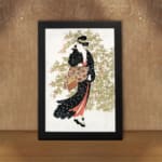 Vintage wall art of a Japanese woman in a black kimono holding a fan, with delicate trees in the background. displayed on the wall in a black frame