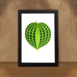Heart-shaped green leaf with light and dark green patterns on a white background, framed in black, vintage botanical wall art displayed on the wall