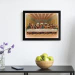 Vintage wall art of the Last Supper with Jesus and his disciples in a detailed, warm-toned biblical setting. displayed on the wall in a black frame