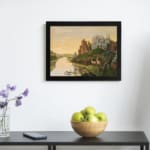 Dreamy vintage river landscape with deer, two castles, and a golden sky in a peaceful fairytale setting. displayed on the wall in a black frame