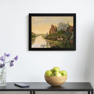 Dreamy vintage river landscape with deer, two castles, and a golden sky in a peaceful fairytale setting. displayed on the wall in a black frame