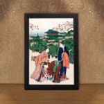 Vintage Japanese wall art of women in kimonos under cherry blossom trees with a temple in the background. displayed on the wall in a black frame