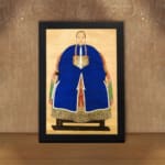 Vintage wall art of a classic East Asian portrait showing a person in a royal blue robe with gold accents on a beige background. displayed on the wall in a black frame