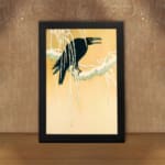 Infidu vintage wall art featuring a black crow perched on a snow-covered tree against a soft beige or light golden background, creating a timeless and artistic winter scene. displayed on the wall art in a black frame
