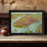 Vintage aerial view of a historic waterfront city with detailed buildings, boats, and earthy tones. displayed on the wall in a black frame