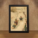 Vintage wall art of a nostalgic winter sledding scene with people in traditional winter clothing on a snowy slope, surrounded by trees. displayed on the wall in a black frame