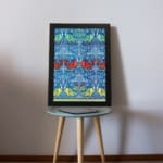 Vintage wall art with intricate decorative patterns in blue, red, green, and yellow, set against a blue background with a black frame. displayed on the wall