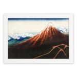 Vintage mountain landscape wall art with red, brown, and blue tones, featuring a striking reddish-brown mountain, blue sky, and white frame. hung on the wall