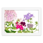 Infidu Vintage Floral Wall Art with soft pink, purple, and deep red flowers, green leaves, and a white background for a timeless, elegant look. hung on the wall on a white background