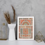 Infidu Vintage Wall Art with intricate geometric patterns in red, orange, beige, teal, and green, featuring symmetrical and decorative designs. displayed on the wall in a white frame