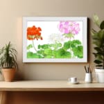 Infidu Vintage Floral Wall Art with orange, pink, and white flowers, green leaves, and a white frame on a white background. displayed on the wall