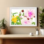 Vintage floral wall art with pink and white roses, red buds, and green leaves in a white frame on a white background. displayed on the wall