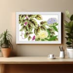 Vintage floral wall art with soft yellow and light purple flowers, green leaves with dark veins, and a white background. displayed on the wall in a white frame