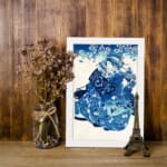 Infidu vintage wall art featuring a graceful figure in a patterned kimono with floral details, set against a soft cherry blossom background in a classic blue and white color scheme. displayed on the wall art in a black frame