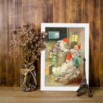 Infidu vintage wall art featuring a hand-painted cozy gnome scene with warm rustic colors, a glowing lantern, and a peaceful night sky view. displayed on the wall art in a white frame
