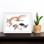 Infidu vintage wall art featuring a playful illustration of a jumping fox and two running rabbits in soft, natural colors against a clean white background. displayed on the wall art in a white frame