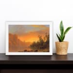 Vintage wall art of a tranquil sunset lake with warm tones, towering cliffs, and lush trees, creating a serene and timeless landscape. displayed on the wall in a white frame
