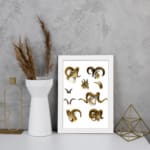 Vintage wall art with detailed ram illustrations in brown, beige, and black, set against a white background, resembling antique natural history prints. displayed on the wall