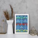Vintage wall art with intricate decorative patterns in blue, red, green, and yellow, set against a blue background with a white frame. displayed on the wall