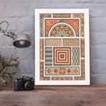 Infidu Vintage Wall Art with intricate geometric patterns in red, orange, beige, teal, and green, featuring symmetrical and decorative designs. displayed on the wall in a white frame
