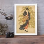 Vintage Japanese wall art of a woman in a kimono with floral patterns, set against a soft green and beige background. displayed on the wall in a white frame