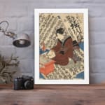 Vintage Japanese ukiyo-e wall art of a scholar writing on a scroll, with intricate calligraphy in the background. displayed on the wall in a white frame
