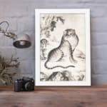 Vintage Asian tiger painting in black and white, featuring bold stripes, expressive eyes, and a natural background with trees and mountains. displayed on the wall