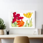 Vintage floral wall art with red, orange, and yellow tulips, green leaves, and a white frame on a white background. displayed on the wall