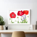Vintage floral wall art with red and purple-white poppies, green leaves, and a black frame on a white background. displayed on the wall